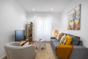 sala de estar con sofá y TV en Sueños Del Mar, en Nazaré