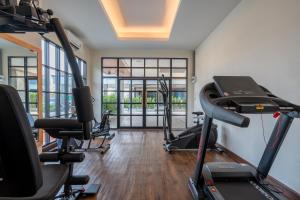 a gym with treadmills and ellipticals in a room at Cozy Blu Suvarnabhumi in Samutprakarn