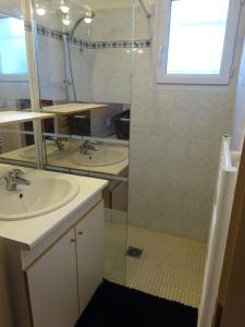 ein Badezimmer mit zwei Waschbecken und einer Glasdusche in der Unterkunft Gîte des Pleiades in Villemoirieu