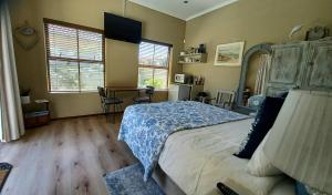 a bedroom with a bed and a desk and windows at Big Bay Homestay in Big Bay