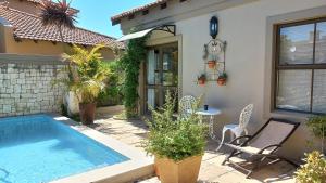 a house with a swimming pool and a table and chairs at Big Bay Homestay in Big Bay