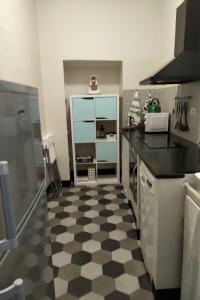 uma cozinha com piso em xadrez preto e branco em DOGE CAMBIASO- Davanti all'acquario - Grande terrazza privata - Palazzo Nobiliare Storico em Gênova