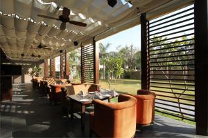 a restaurant with tables and chairs and a ceiling fan at Hotel Express Residency Vadodara in Vadodara