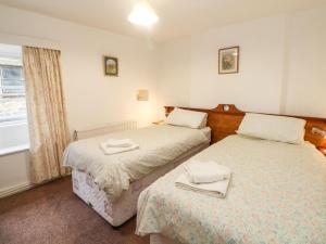 a bedroom with two beds with towels on them at Sycamore Cottage in Hucklow