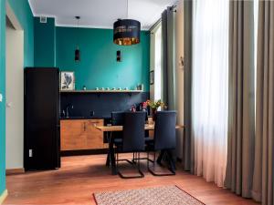 a dining room with green walls and a table and chairs at Apartament Inspirujący - z prywatnym monitorowanym parkingiem - 4 osobowy - Space Apart in Jelenia Góra