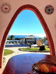 an archway over a pool with a view of the ocean at Casa Granero in Frigiliana
