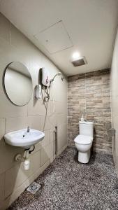 uma casa de banho com um WC, um lavatório e um espelho. em Hotel Lavender Inn em Malaca