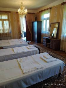 a group of four beds in a room with a mirror at Guest House TeNi in Makhinjauri