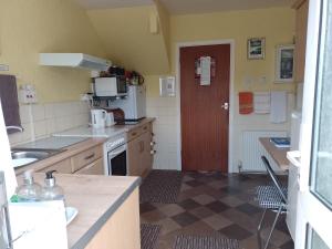 eine Küche mit einem Waschbecken und einer roten Tür in der Unterkunft SUPER SINGLE ROOM in Cardiff