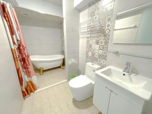 a bathroom with a toilet and a sink and a tub at 南鴻雅築South Home in Nanwan