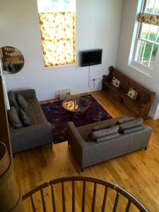 a living room with two couches and a flat screen tv at Acorn Chapel - Beautiful Converted Chapel in Norwich