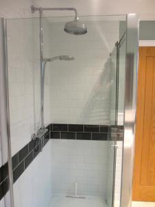 a shower with a glass door in a bathroom at Acorn Chapel - Beautiful Converted Chapel in Norwich