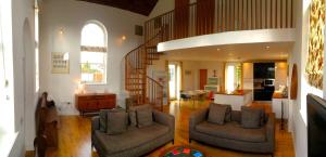 a living room with two couches and a staircase at Acorn Chapel - Beautiful Converted Chapel in Norwich