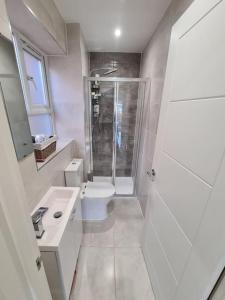 y baño blanco con ducha y aseo. en Panorama House, Luxury 2-Bedroom Apartment 2 en Kidlington
