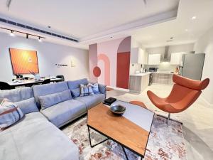 a living room with a blue couch and a table at Cadee Living - Al Nakheel in Riyadh