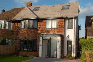 a red brick house with a white door at Panorama House, Luxury 2-Bedroom Apartment 2 in Kidlington