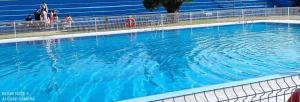 una gran piscina con agua azul. en Navarubia en Navacerrada