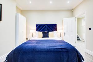 a bedroom with a large bed with a blue blanket at Hybrid Resi - Battersea in London
