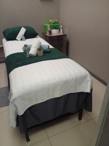 Schlafzimmer mit einem großen Bett mit grüner und weißer Bettwäsche in der Unterkunft DeeCinta Health Spa in Johannesburg