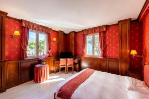 a bedroom with red walls and a bed and a desk at Hotel Du Lac Menaggio in Menaggio
