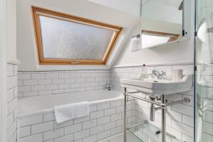 a bathroom with a sink and a bath tub and a window at Danny Lodge - Country Cottage Near Brighton by Huluki Sussex Stays in Hurstpierpoint