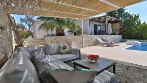 a patio with a couch and a table and a pool at Villa Meli in Rethymno Town