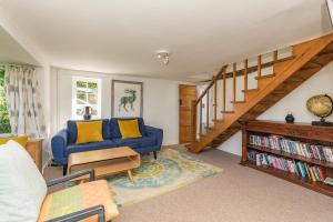 sala de estar con sofá azul y escalera en Danny Lodge - Country Cottage Near Brighton by Huluki Sussex Stays, en Hurstpierpoint