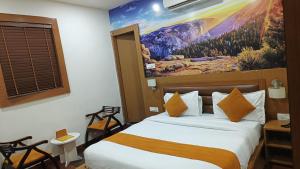 a bedroom with a bed with a painting on the wall at Banyan hotel&restro in Hisār