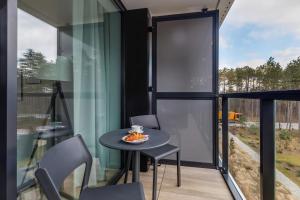 a room with a table and chairs and a window at Modern Shellter Apartment Beachside Rogowo by Renters in Rogowo