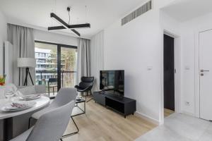 A television and/or entertainment centre at Modern Shellter Apartment Beachside Rogowo by Renters