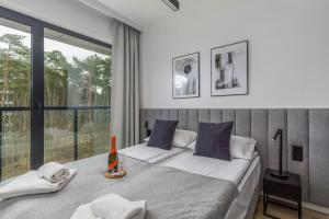 1 dormitorio con 2 camas y ventana grande en Modern Shellter Apartment Beachside Rogowo by Renters en Rogowo