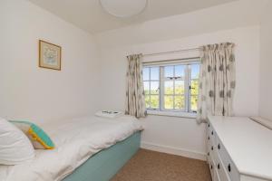 a bedroom with a bed and a window at Danny Lodge - Country Cottage Near Brighton by Huluki Sussex Stays in Hurstpierpoint