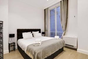 Schlafzimmer mit einem großen Bett und einem Fenster in der Unterkunft Pick A Flat's Apartment in Triangle d'Or - Pierre 1er de Serbie in Paris