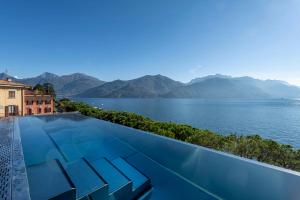 a swimming pool with a view of the water and mountains at Hotel Du Lac Menaggio in Menaggio