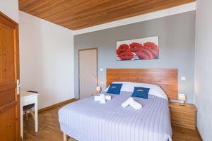 a bedroom with a white bed with blue pillows at San Larenzu in Aullène