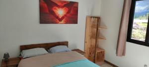 1 dormitorio con 1 cama y una foto en la pared en La maison Loé, en Cilaos