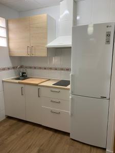 una cucina con elettrodomestici bianchi e frigorifero bianco di Apartment Triana 2 a Siviglia