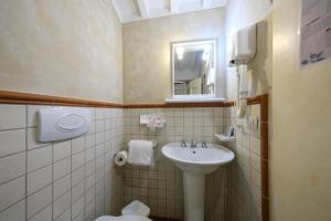 a small bathroom with a sink and a mirror at San Tommaso in Pisa