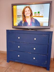 un televisor en la parte superior de una cómoda azul con una mujer en Ferienwohung Charlotte, en Usedom Town