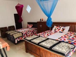 een slaapkamer met 2 bedden en blauwe gordijnen bij Hotel Meer in Ambalangoda