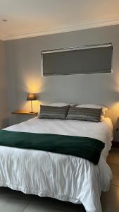 a bedroom with a large white bed with two pillows at Robyns Nest 3 Self Catering Flat in Kloof