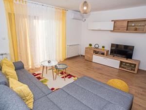 a living room with a blue couch and a tv at Apartment Ivona Tribalj in Tribalj