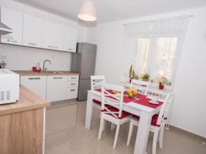 a kitchen with a white table and chairs in a kitchen at Apartment Ivona Tribalj in Tribalj