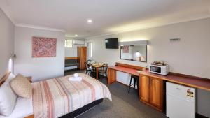 a hotel room with a bed and a microwave at Kempsey Powerhouse Motel in Kempsey