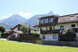 ein großes Haus mit Bergen im Hintergrund in der Unterkunft Haus Alpenblume in Ehrwald