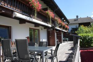 a table and chairs outside of a building with flowers at Haus Alpenblume in Ehrwald