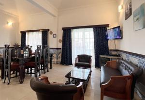 uma sala de estar com um sofá, uma mesa e cadeiras em Villa Marina By The Beach Goa em Benaulim