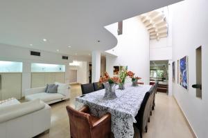 a dining room with a table with chairs and a couch at Luxury villa with a heated pool, Jakuzi and a sea view 70m from the beach in Herzliya