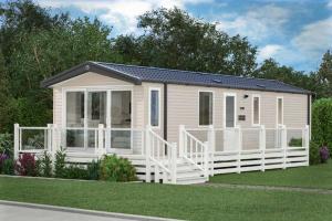 a small house with a white fence at The Spey Van - Beautiful, luxury static caravan in Aberlour
