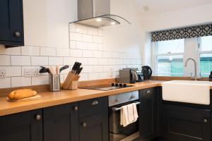 a kitchen with black cabinets and a sink at West Lodge - Seasgair Lodges in Kincraig +2 photos